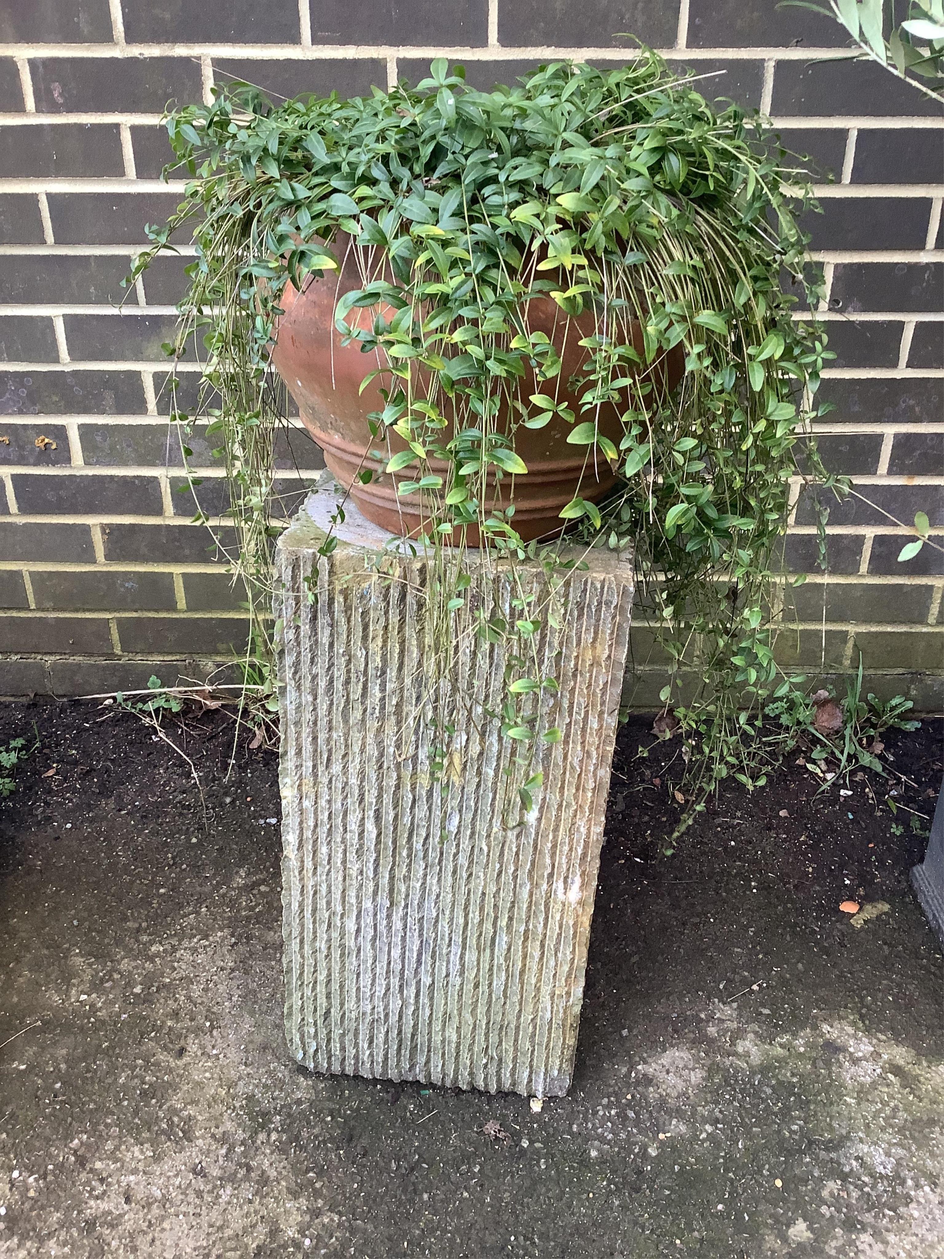 A square section ribbed stone plinth, surmounted by a terracotta pot, height 91cm. Condition - fair